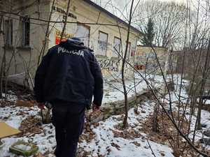 na zdjęciu policjant idący przez teren nieużytków