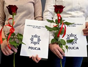dwie osoby trzymają w dłoniach róże i teczki z napisem Komendant Miejski Policji w Bytomiu
