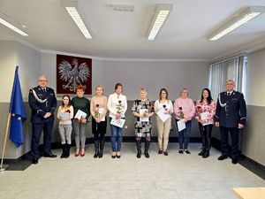 na zdjęciu stojący w rzędzie pracownicy cywilni przy nich policjanci