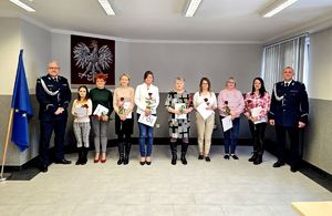 na zdjęciu stojący w rzędzie pracownicy cywilni przy nich policjanci