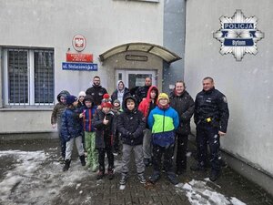 na zdjęciu uczniowie i mundurowi przed budynkiem komisariatu