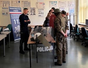 na zdjęciu stoisko policyjne przy nim policjant i uczniowie