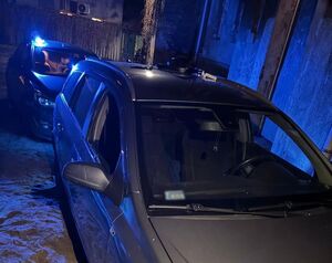 samochód szarego koloru, za nim nieoznakowany radiowóz