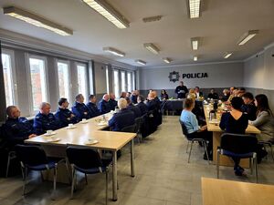 policjanci, zaproszeni goście i pracownicy cywilni siedzący przy stołach