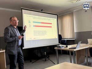 mężczyzna stojący przy wyświetlonym slajdzie prezentacji