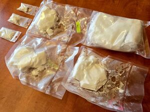 leżące na stole woreczki strunowe z białą sypką substancją, cztery duże i trzy małe