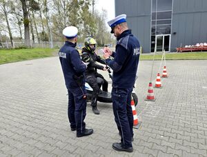 widzimy dwóch policjantów drogówki, przed nimi uczestnik turnieju na motorowerze