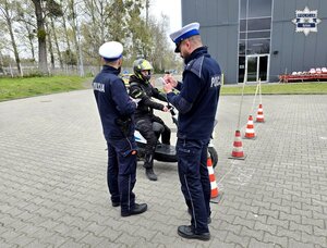 widzimy dwóch policjantów drogówki, przed nimi uczestnik turnieju na motorowerze