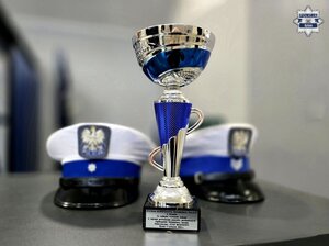 puchar, za nim dwie czapki policjantów ruchu drogowego