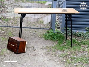 ławka, obok na ziemi uszkodzona drewniana skarbona