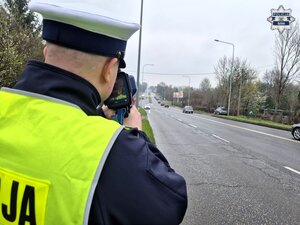 policjant ruchu drogowego wykonujący pomiar prędkości kierujących