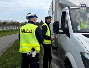 dwaj policjanci ruchu drogowego przy pojeździe ciężarowym