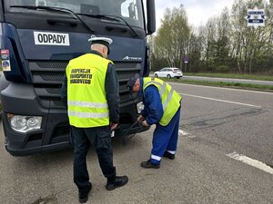 funkcjonariusz Inspekcji Transportu Drogowego i kierowca pojazdu ciężarowego przy aucie