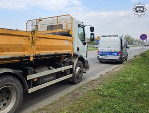 radiowóz służbowy za nim pojazd ciężarowy