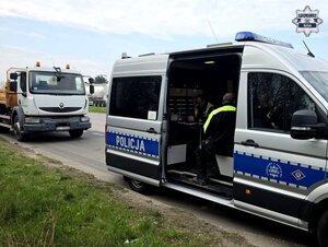 radiowóz służbowy za nim pojazd ciężarowy