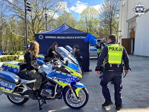 policjanci, motocykle służbowe, na nich dwie dziewczyny, za nimi stoisko policyjne