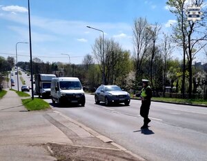 policjant na drodze wykonuje pomiar prędkości