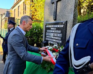 prezydent Bytomia składa kwiaty przy obelisku Sienickiego, obok policjanci