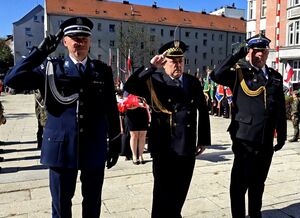 salutujący przed pomnikiem komendant bytomskiej jednostki, komendant straży pożarnej i komendant straży miejskiej