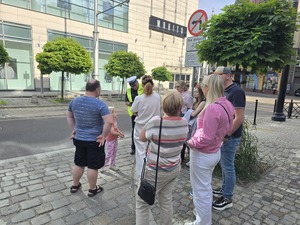 policjant drogówki z ręcznym miernikiem prędkości obok niego dzieci