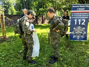 dwóch chłopców w strojach moro i policjanci podczas konkurencji z pierwszej pomocy