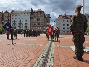 uczniowie klas mundurowych w strojach moro ustawieni na rynku