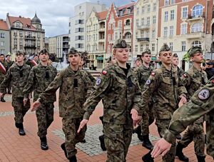 maszerujący uczniowie klas mundurowych w strojach moro
