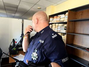 policjant trzyma stację w dłoni przy ustach