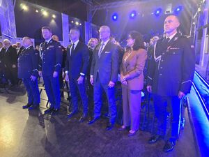 goście i mundurowi stoją w rzędach na sali