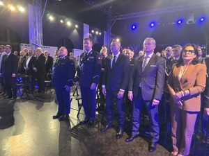 goście i mundurowi stoją w rzędach na sali