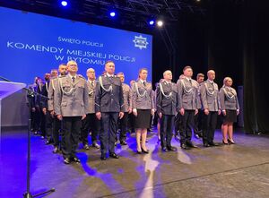 policjantki i policjanci stoją w kilku rzędach na sali przed mianowaniem na kolejne stopnie