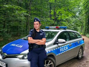 policjantka stojąca przed radiowozem