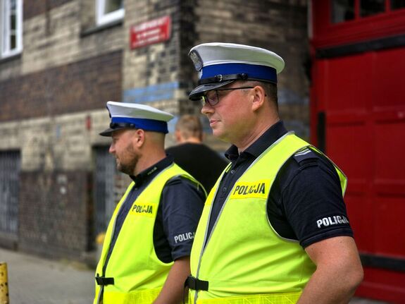 widzimy dwóch policjantów ruchu drogowego stojących przy szkole