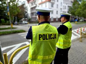 widzimy dwóch policjantów ruchu drogowego stojących przy szkolnym przejściu dla pieszych