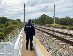 policjant stojący na wiadukcie kolejowy