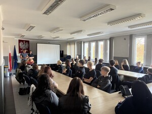 licealiści siedzący w sali przed nimi policjant i policjantka