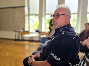 policjant w okularach siedzący na krześle